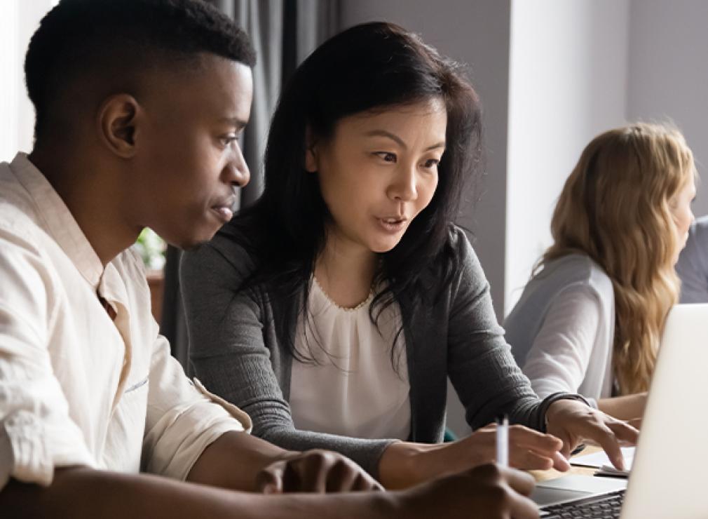 Female mentor helping student on laptop